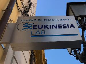 Realizzazione Insegna luminosa a bandiera in dibond traforata - Eukinesia